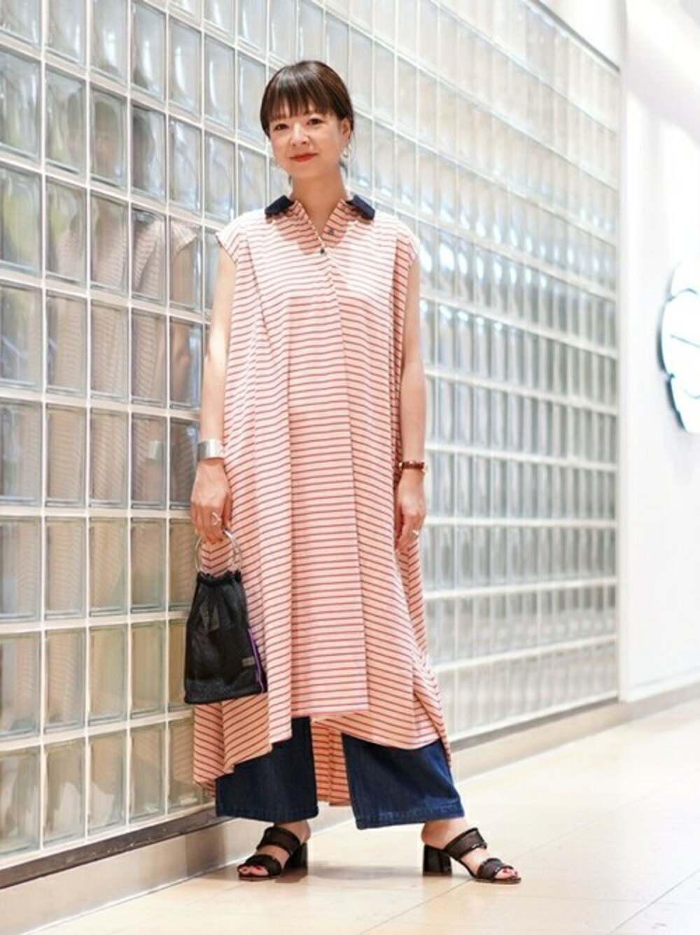 ブラック系のトートバッグ、ブラック系のサンダル、ベージュ系のワンピースを着用したレディースの夏コーディネートの1枚目の写真