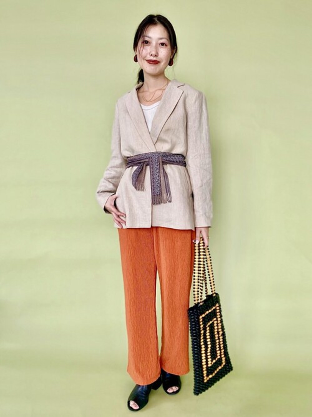 ベージュ系のその他アウター、オレンジ系のその他パンツ、ブラック系のトートバッグを着用したレディースの夏コーディネートの1枚目の写真