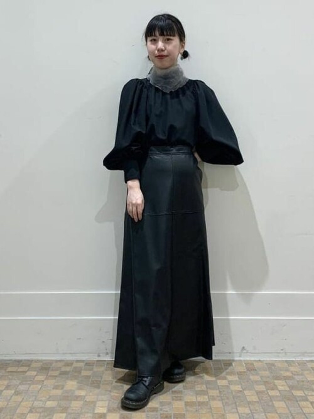 ブラック系のスカート、ブラック系のシャツ/ブラウス、ブラック系のブーツを着用したレディースの秋コーディネートの1枚目の写真