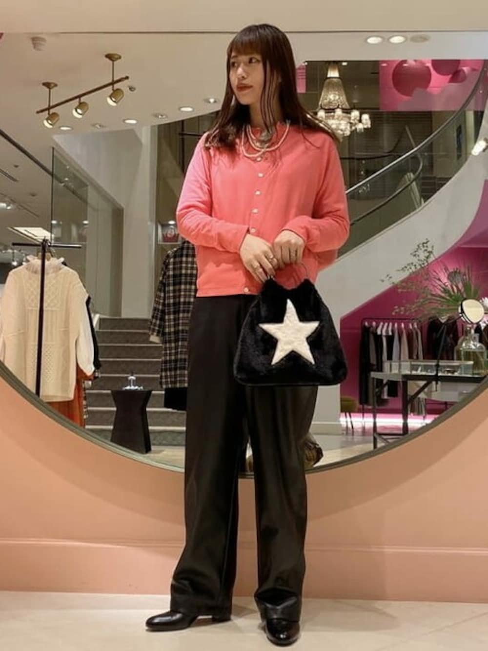 ピンク系のカーディガン/ボレロ、ブラック系のその他パンツ、ブラック系のブーツを着用したレディースの秋コーディネートの1枚目の写真