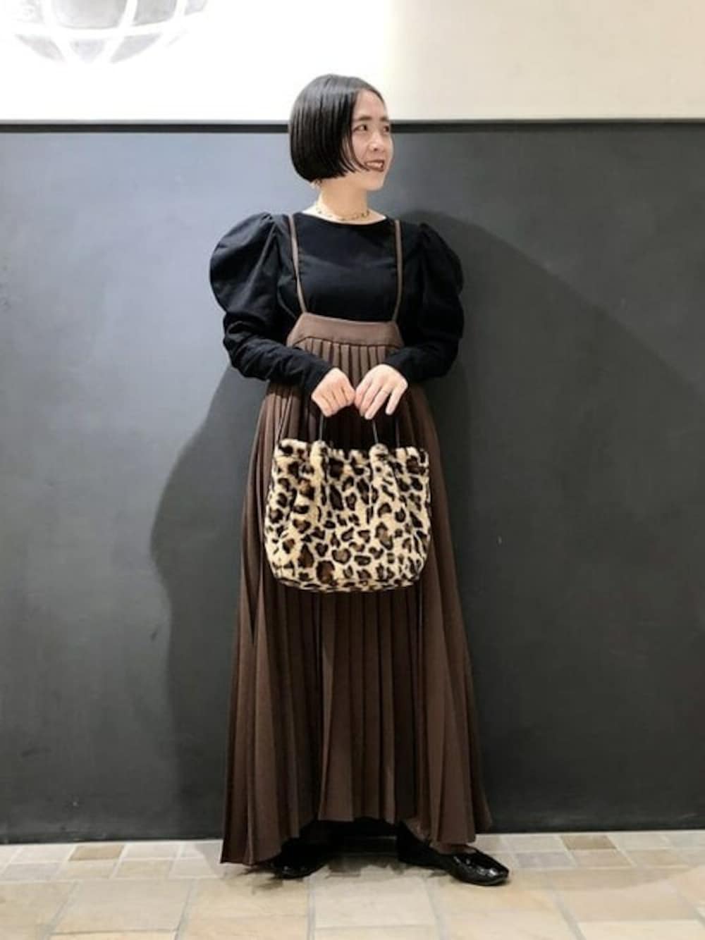 ブラウン系のスカート、ブラック系のTシャツ/カットソー、その他のトートバッグを着用したレディースの冬コーディネートの1枚目の写真