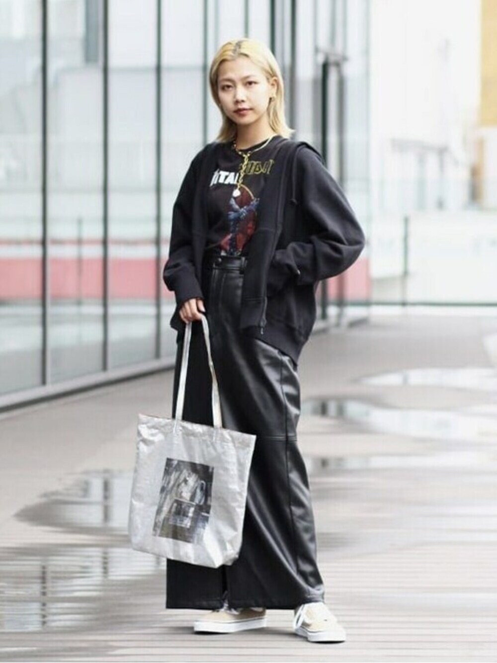 シルバー系のトートバッグ、ブラック系のパーカーを着用したレディースの冬コーディネートの1枚目の写真