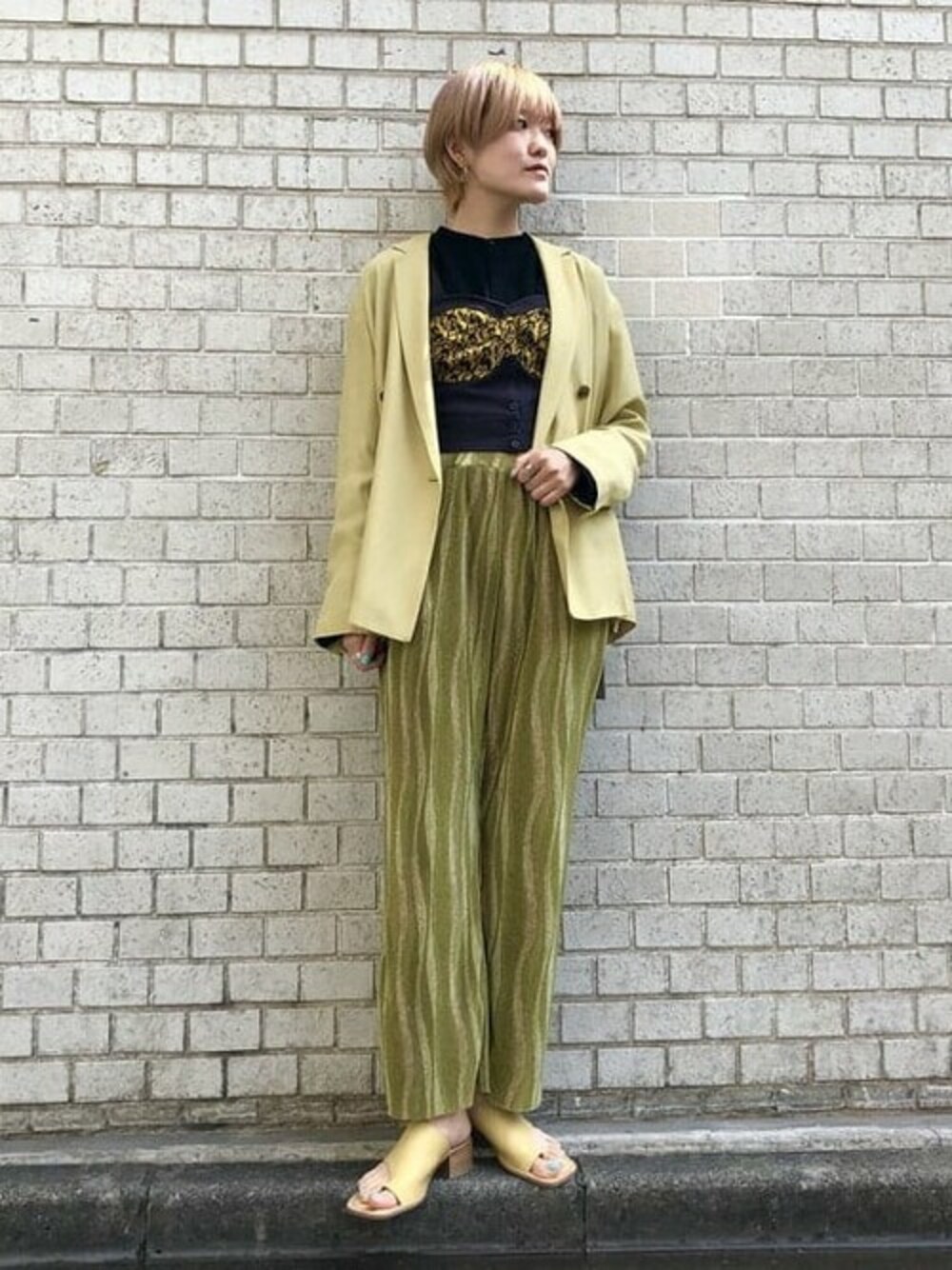 ベージュ系のその他アウター、グリーン系のその他パンツを着用したレディースの春コーディネートの1枚目の写真