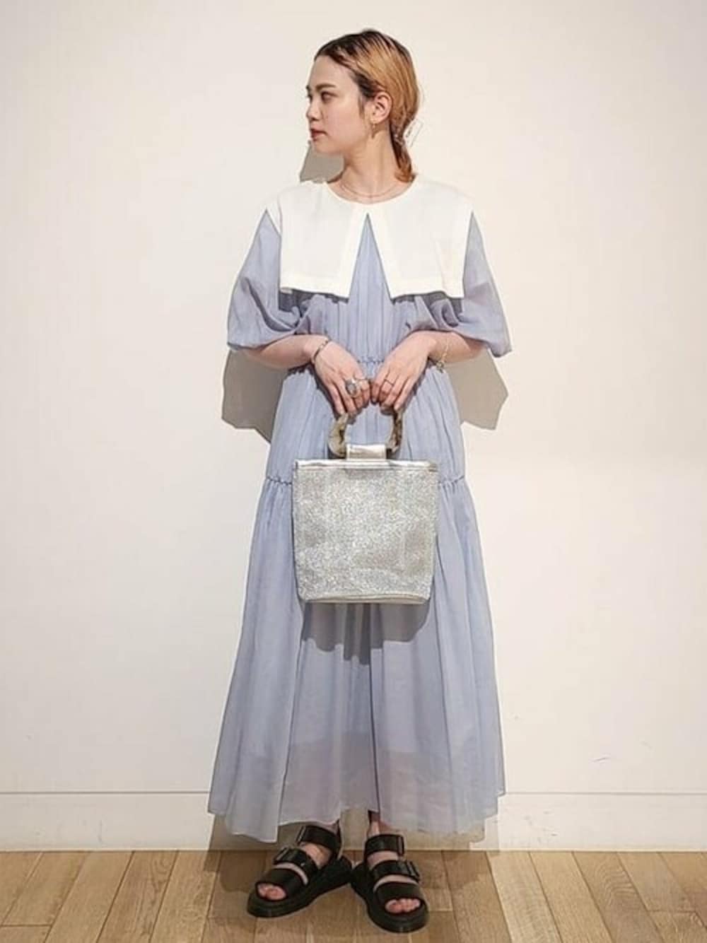 ホワイト系のTシャツ/カットソー、シルバー系のハンドバッグ、ブラック系のサンダルを着用したレディースの夏コーディネートの1枚目の写真