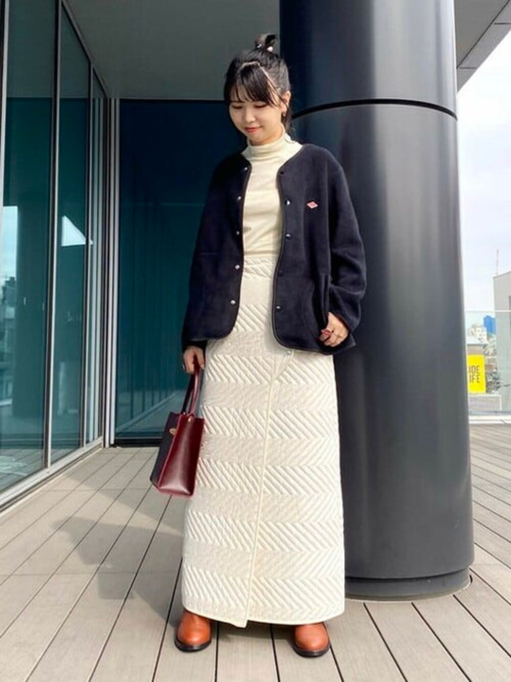 ブラック系のノーカラージャケット、ホワイト系のTシャツ/カットソー、ブラウン系のブーツを着用したレディースの秋コーディネートの1枚目の写真