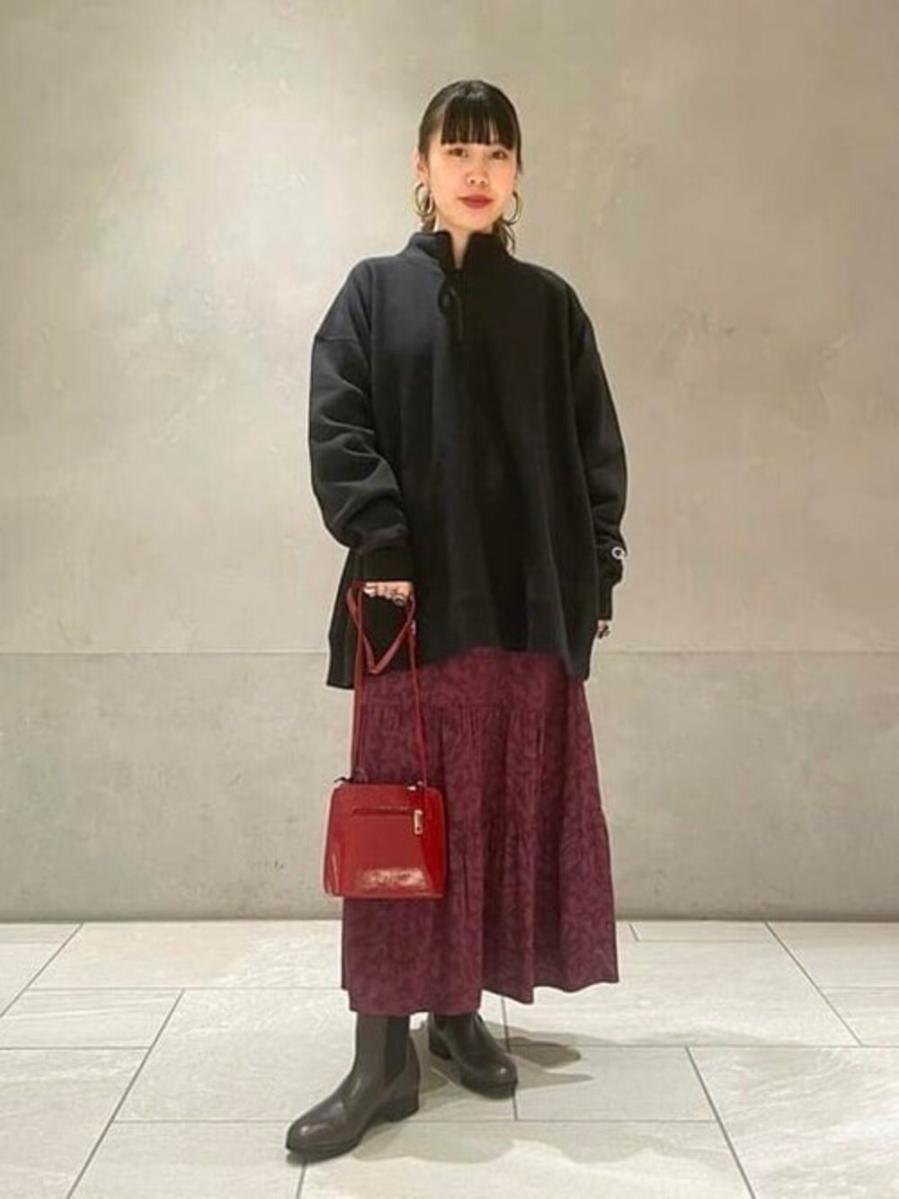 ブラック系のスウェット、レッド系のショルダーバッグ、レッド系のワンピースを着用したレディースの秋コーディネートの1枚目の写真