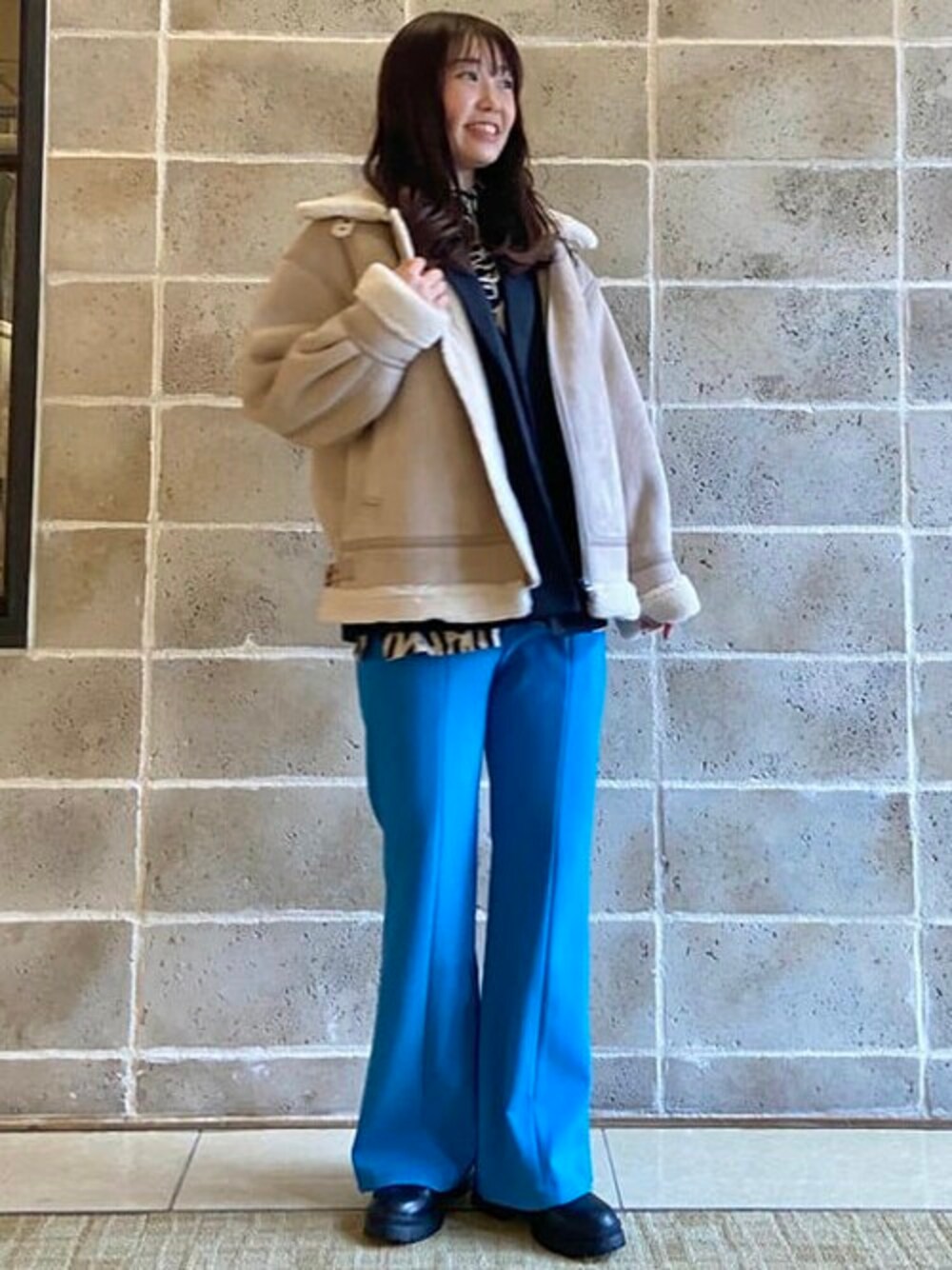 ベージュ系のブルゾン、ブラック系のその他アウター、ブルー系のその他パンツを着用したレディースの秋コーディネートの1枚目の写真