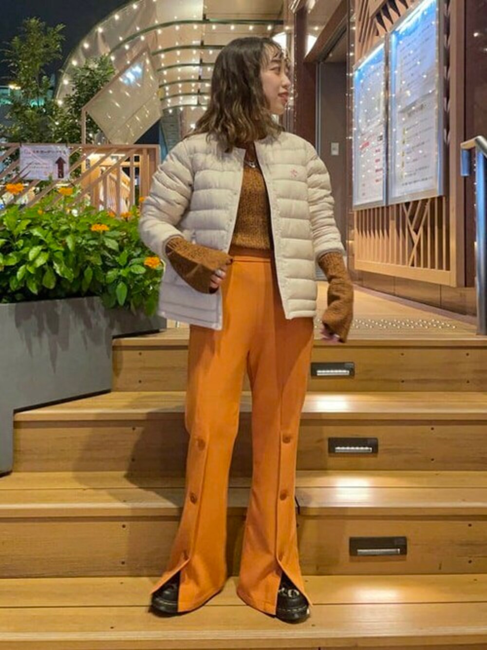 オレンジ系のその他パンツ、オレンジ系のニット/セーター、ホワイト系のダウンジャケット/コートを着用したレディースの秋コーディネートの1枚目の写真