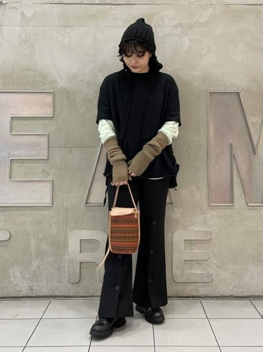 ブラック系のその他パンツ、レッド系のショルダーバッグ、グリーン系のTシャツ/カットソーを着用したレディースの秋コーディネートの1枚目の写真