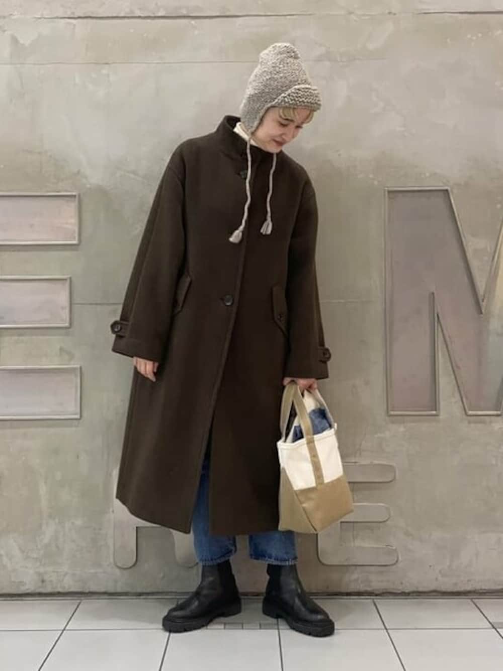 ベージュ系のトートバッグ、ブラウン系のその他アウター、ベージュ系のTシャツ/カットソーを着用したレディースの秋コーディネートの1枚目の写真