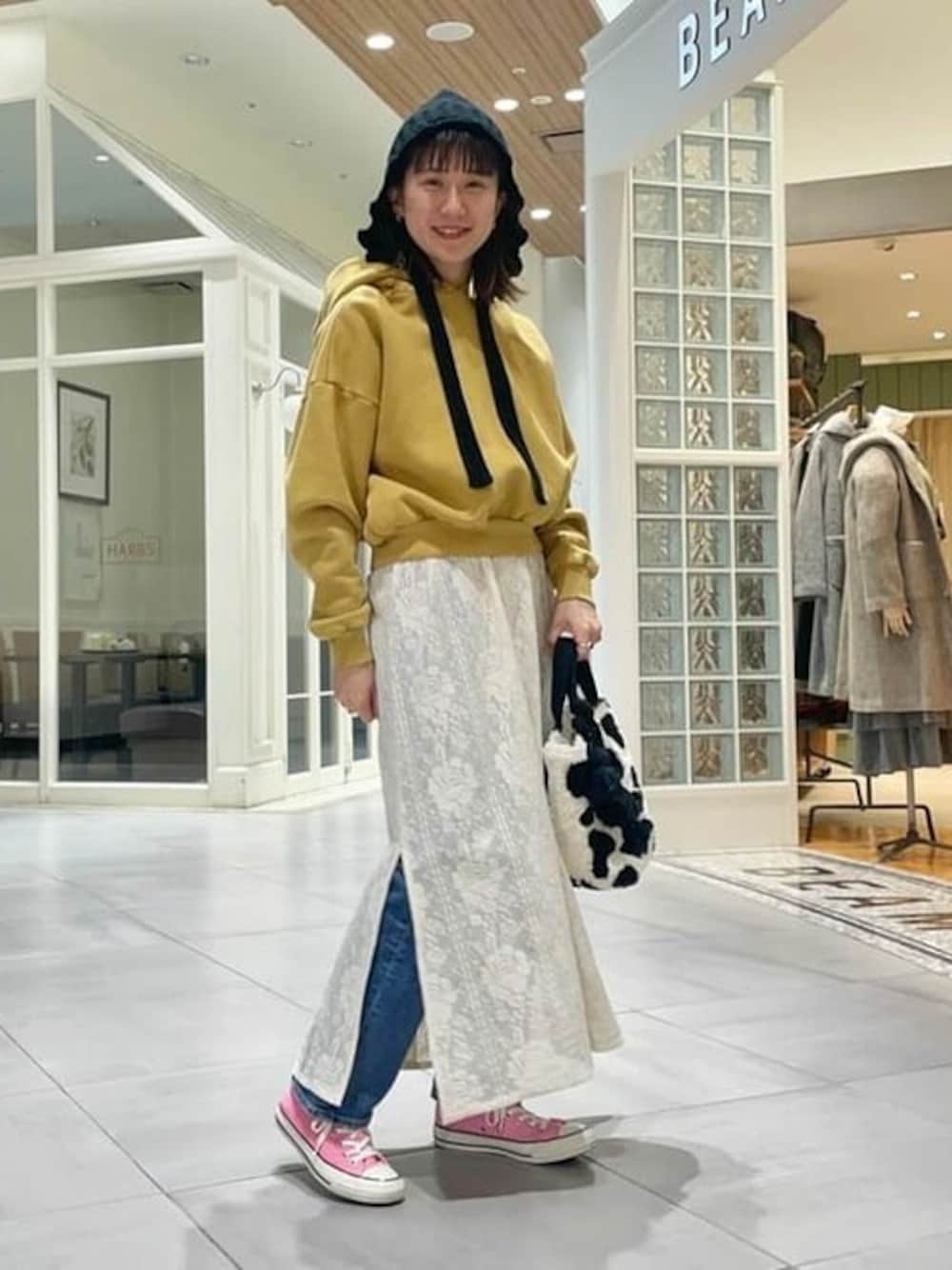 ブラック系のトートバッグ、ベージュ系のワンピース、イエロー系のスウェットを着用したレディースの冬コーディネートの1枚目の写真