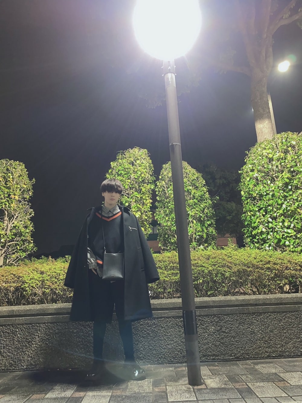 「大人カジュアル、ブラックコーデ、ローファー、スキニーパンツ、チェックシャツ、チルデンニット、ステンカラーコート、ショルダーバッグ、HARE」｜「AlpinusのAlpinus - メルトンロングステンカラーコート（ステンカラーコート、ブラック系）」を使った、じゃないもさん（メンズ・167cm）の春コーディネートの1枚目の写真
