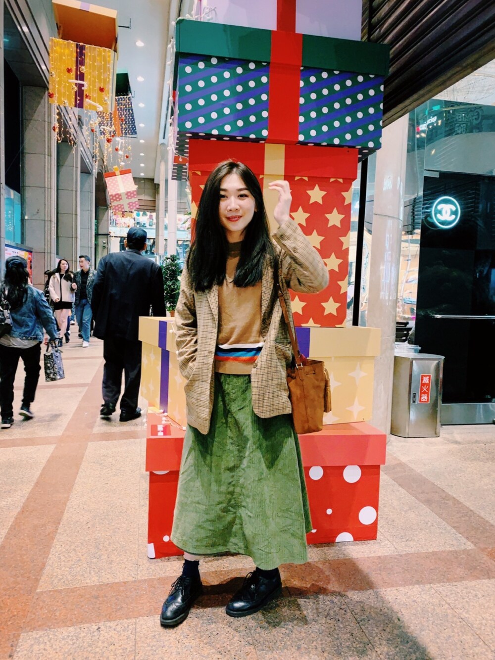 ブラウン系のトップス、グリーン系のスカート、ブラック系のその他シューズを着用したレディースの秋コーディネートの1枚目の写真