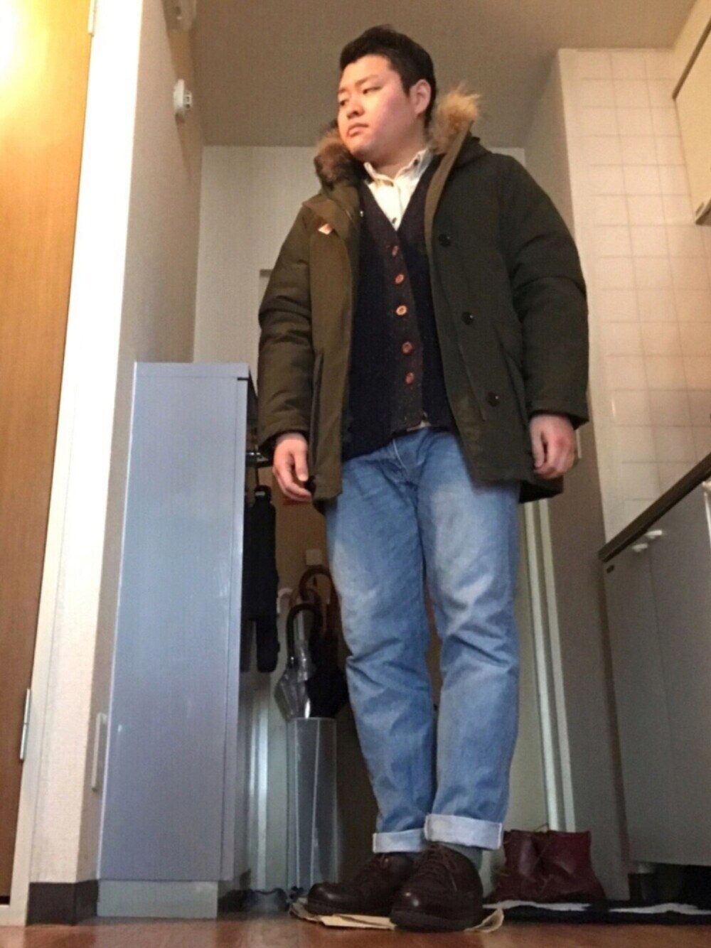 グリーン系のダウンジャケット/コート、ホワイト系のシャツ/ブラウス、ブルー系のデニムパンツを着用したメンズの冬コーディネートの1枚目の写真