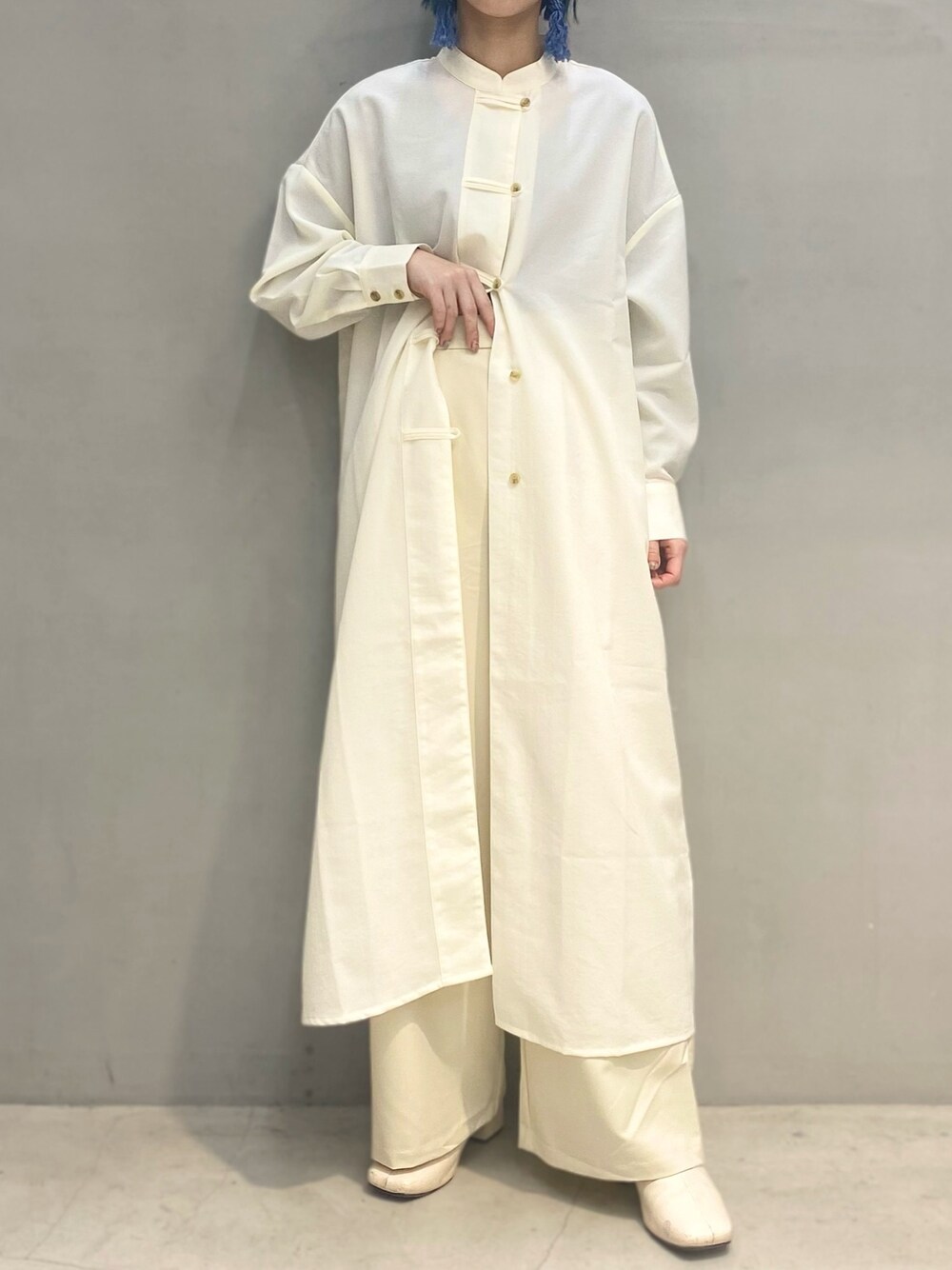 ホワイト系のシャツワンピース、ホワイト系のスラックス、ホワイト系のブーツを着用したレディースの春コーディネートの1枚目の写真