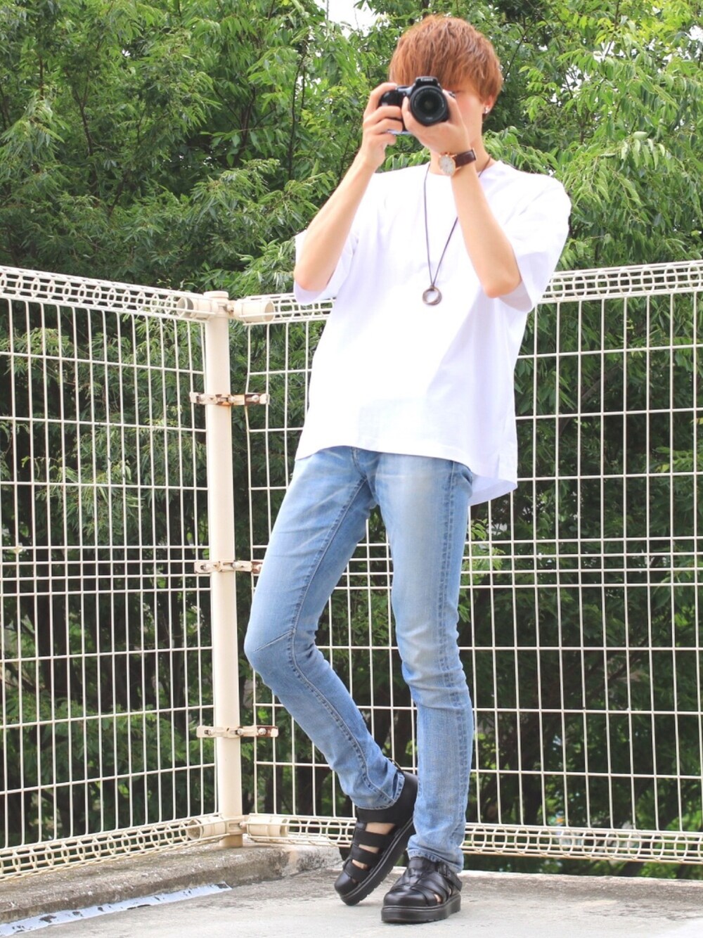 ホワイト系のTシャツ/カットソー、ブルー系のデニムパンツ、ブラック系のサンダルを着用したメンズの夏コーディネートの1枚目の写真