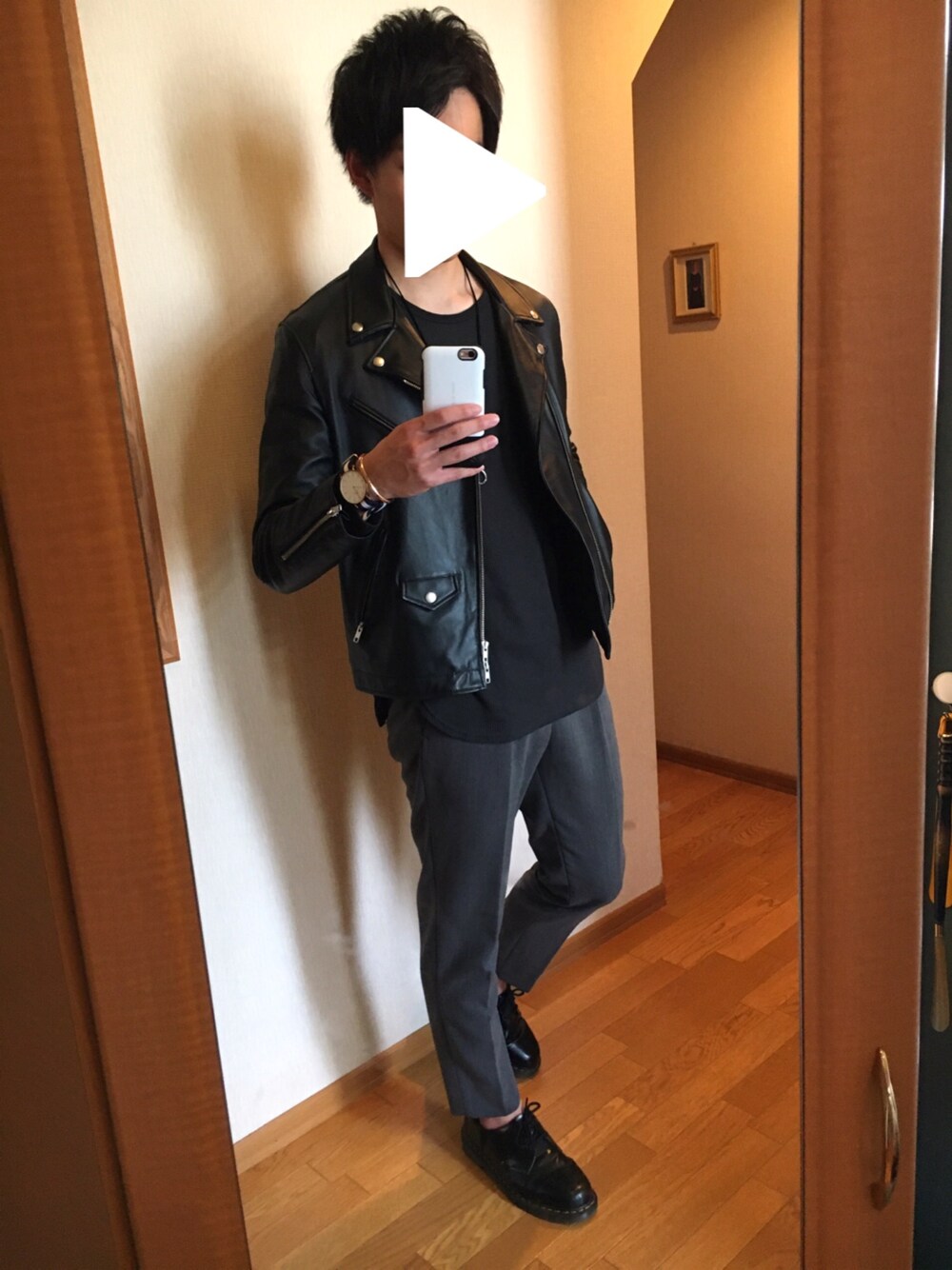 ブラック系のライダースジャケット、ブラック系のTシャツ/カットソー、グレー系のスラックスを着用したメンズの春コーディネートの1枚目の写真