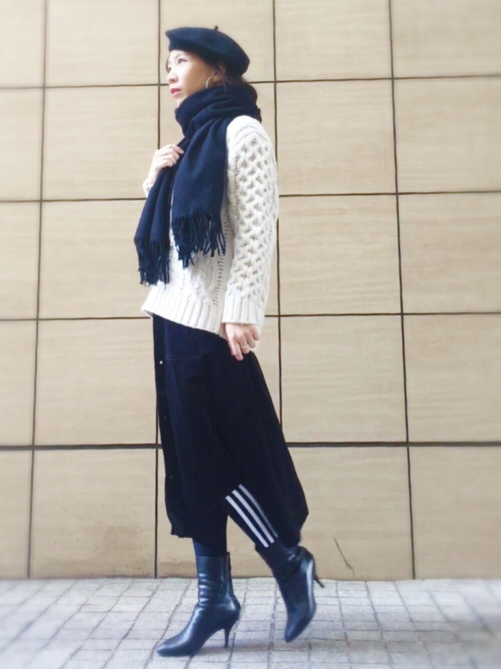 ホワイト系のニット/セーター、ブラック系のスカート、ブラック系のブーツを着用したレディースの冬コーディネートの1枚目の写真