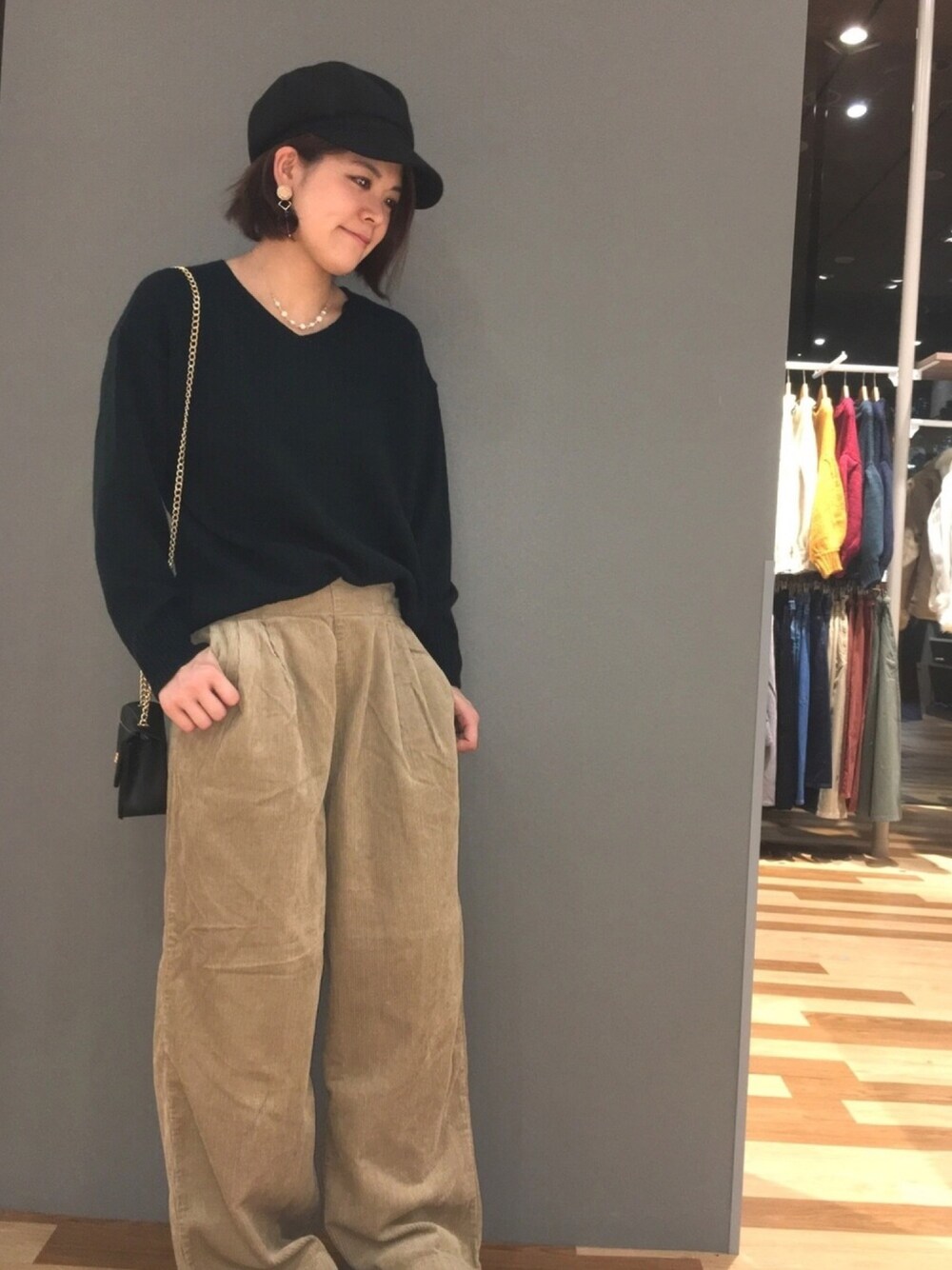 グリーン系のニット/セーター、ベージュ系のその他パンツ、ブラック系のショルダーバッグを着用したレディースの秋コーディネートの1枚目の写真