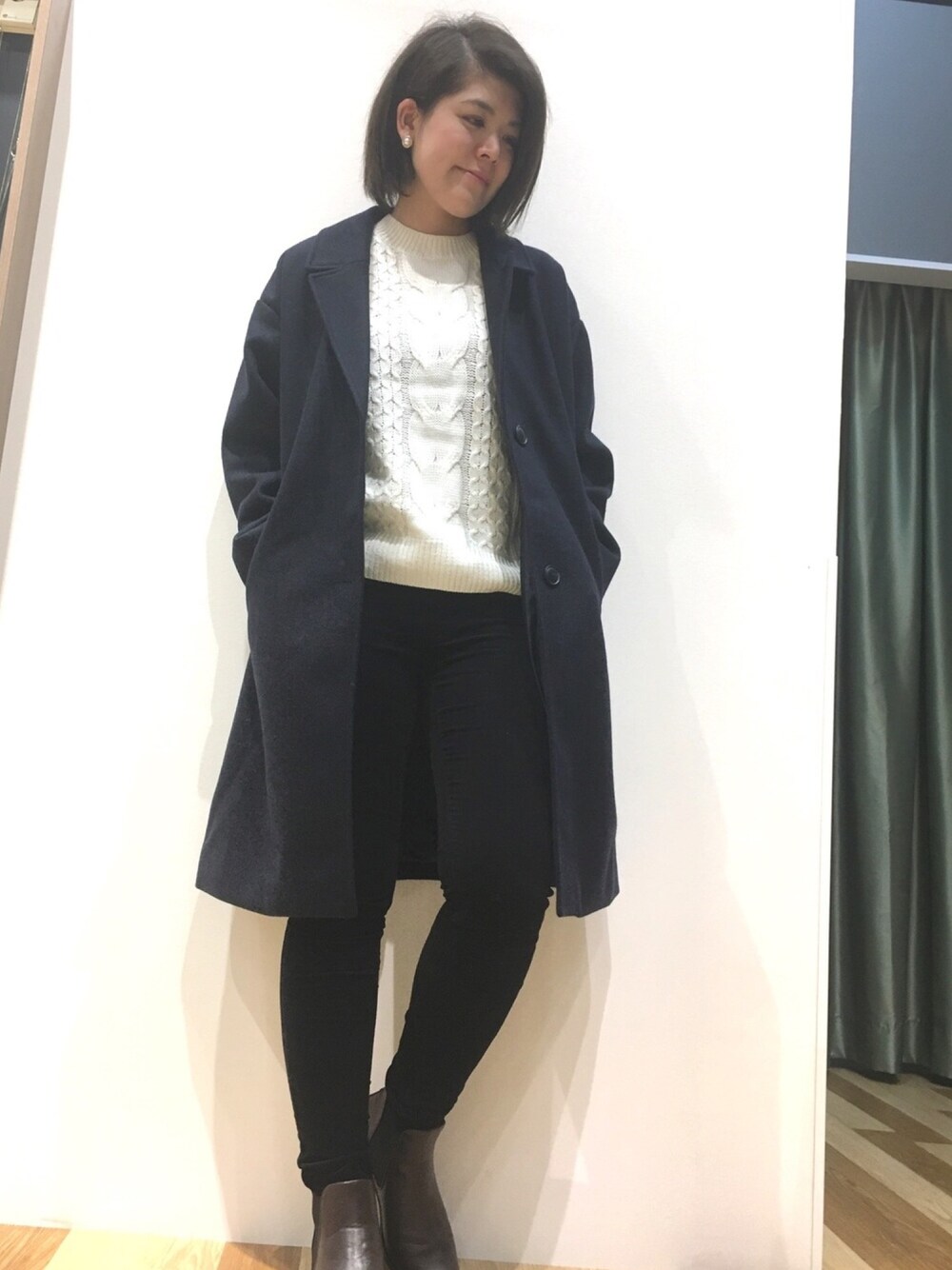 ブルー系のチェスターコート、ホワイト系のニット/セーター、ブラック系のその他パンツを着用したレディースの秋コーディネートの1枚目の写真