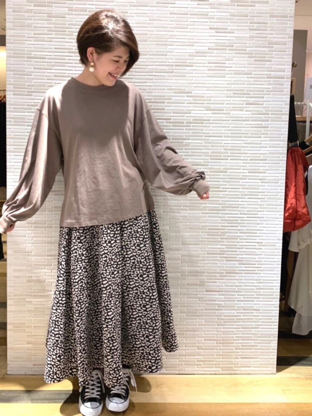 ブラウン系のTシャツ/カットソー、ブラック系のスカート、ブラック系のスニーカーを着用したレディースの夏コーディネートの1枚目の写真