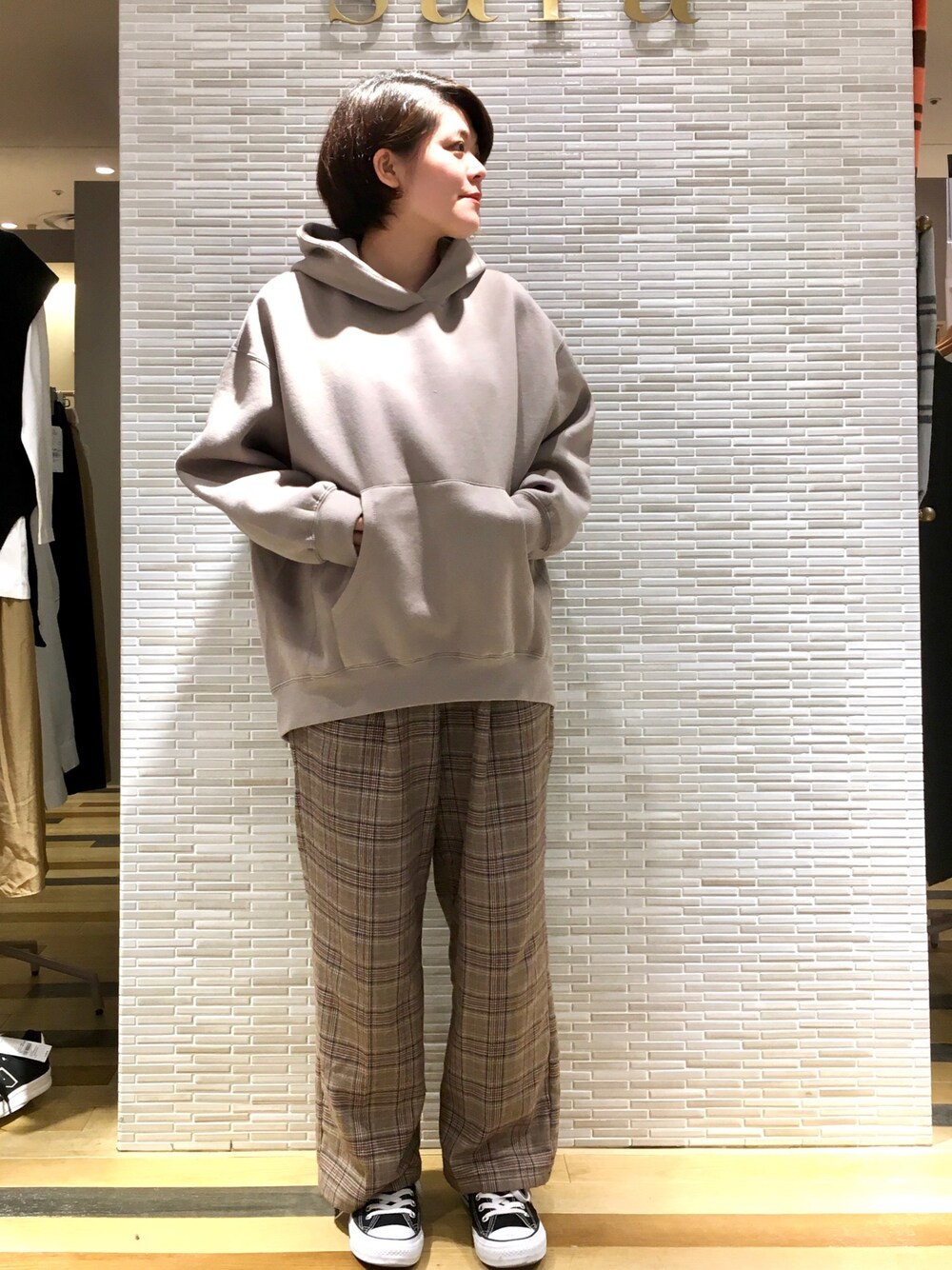 ベージュ系のパーカー、ブラウン系のその他パンツ、ブラック系のスニーカーを着用したレディースの秋コーディネートの1枚目の写真