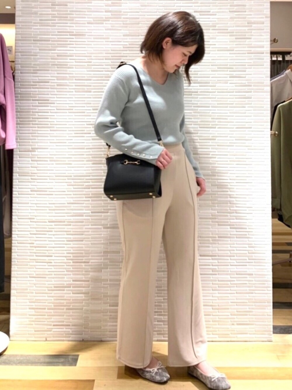 グリーン系のニット/セーター、ベージュ系のその他パンツ、その他のパンプスを着用したレディースの春コーディネートの1枚目の写真