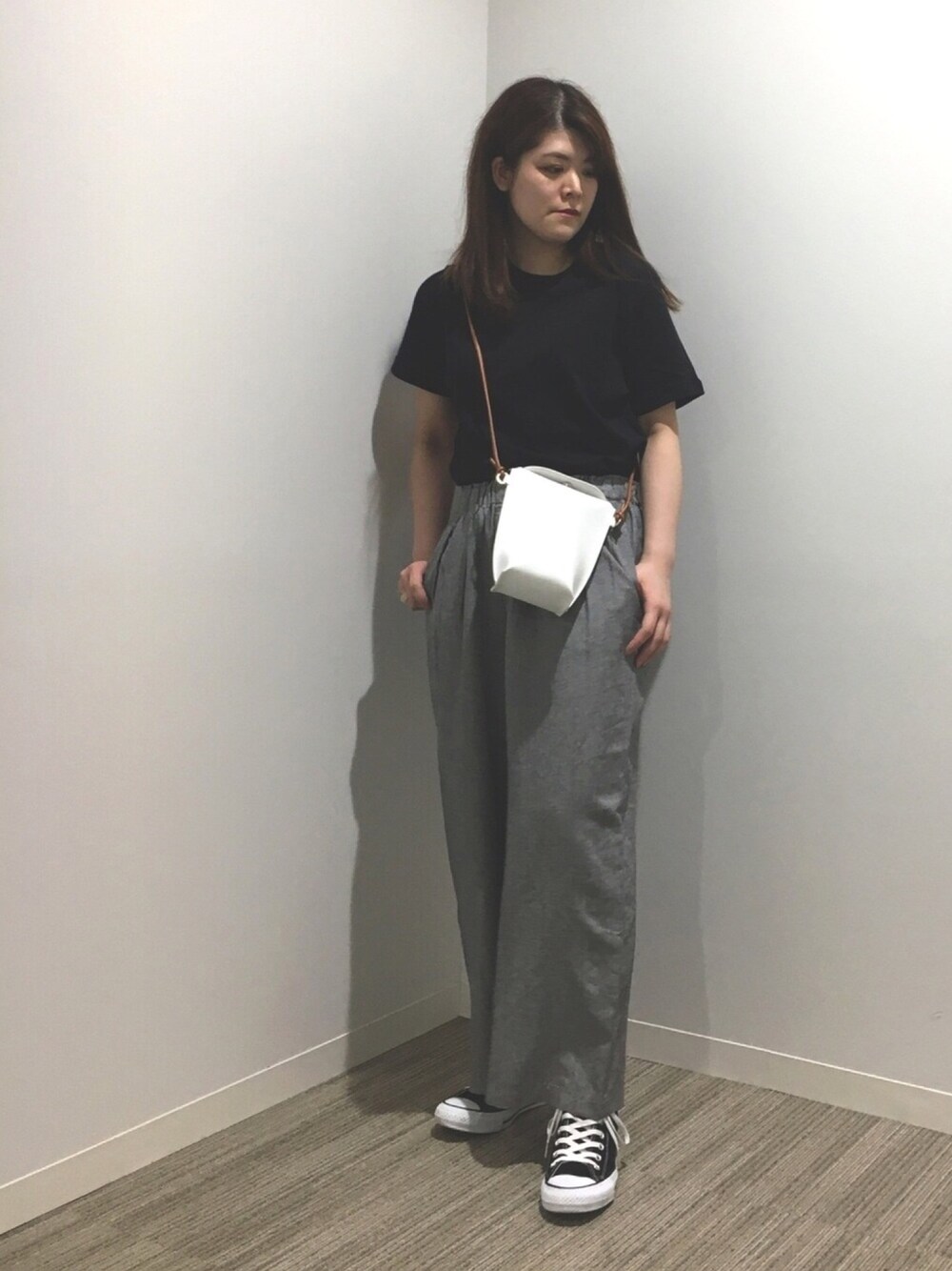 ブラック系のTシャツ/カットソー、ホワイト系のショルダーバッグ、ブラック系のスニーカーを着用したレディースの春コーディネートの1枚目の写真