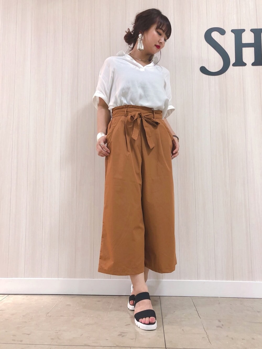 ホワイト系のシャツ/ブラウス、ブラウン系のその他パンツ、ブラック系のサンダルを着用したレディースの夏コーディネートの1枚目の写真