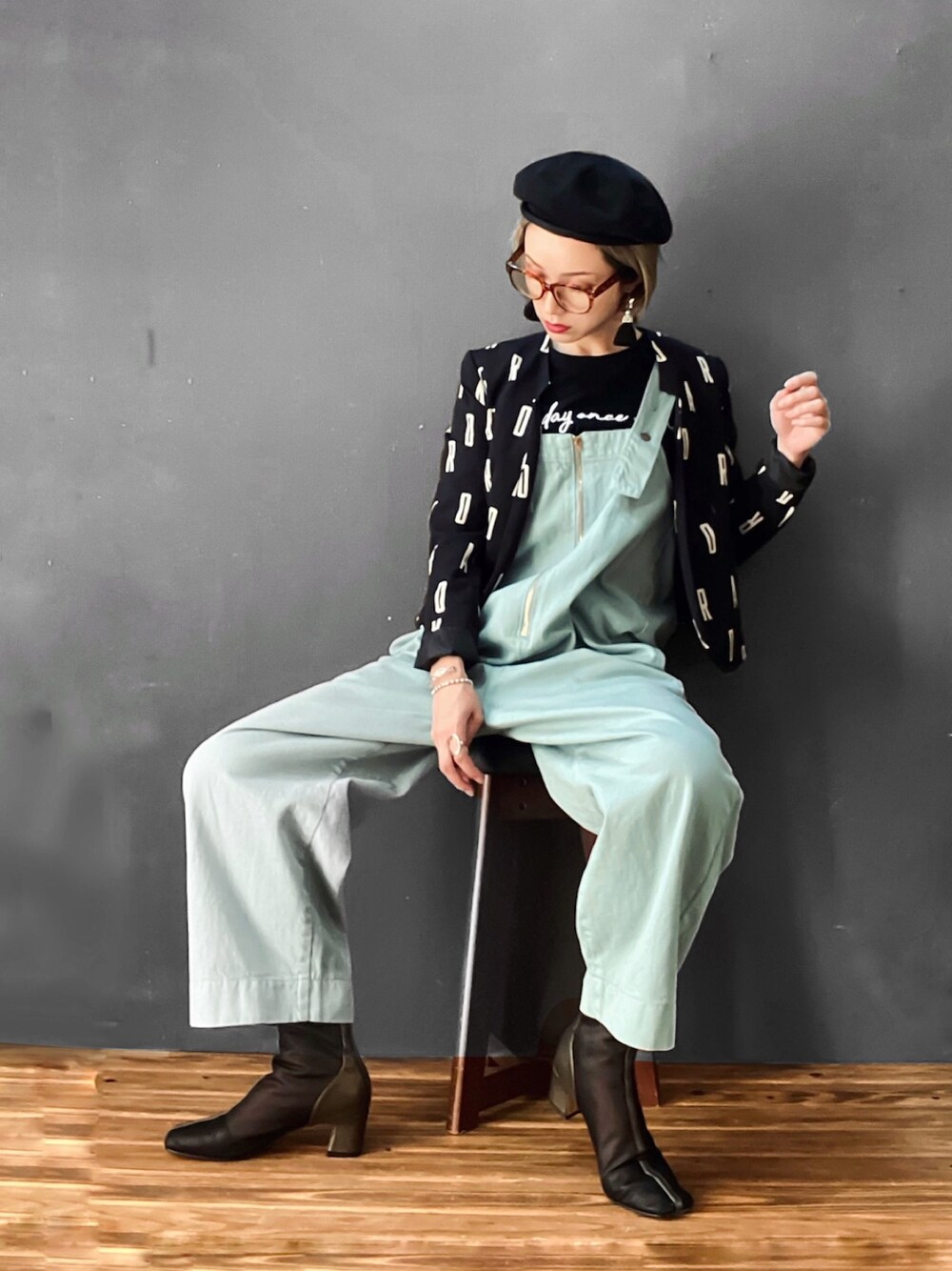 ブルー系のサロペット/オーバーオール、ブラック系のTシャツ/カットソー、ゴールド系のブーツを着用したレディースの夏コーディネートの1枚目の写真