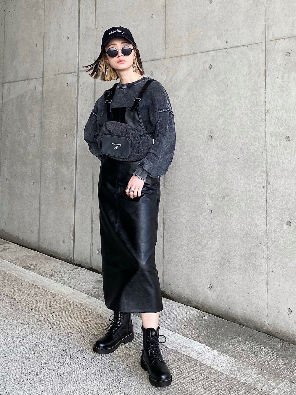 ブラック系のワンピース、ブラック系のスウェット、ブラック系のブーツを着用したレディースの冬コーディネートの1枚目の写真