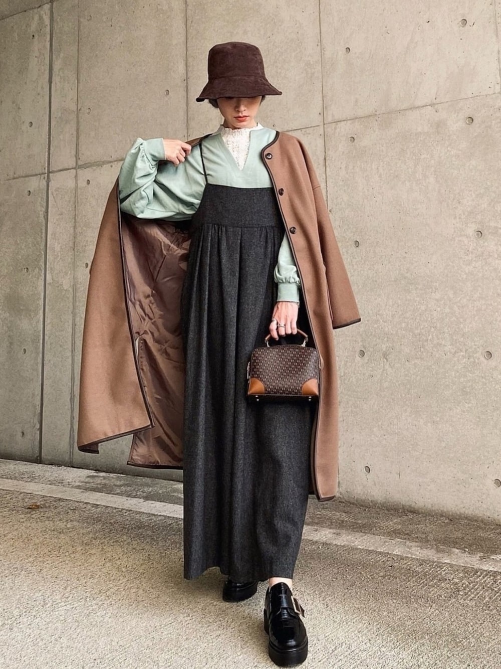 グレー系のサロペット/オーバーオール、グリーン系のTシャツ/カットソー、ブラック系のローファーを着用したレディースの秋コーディネートの1枚目の写真