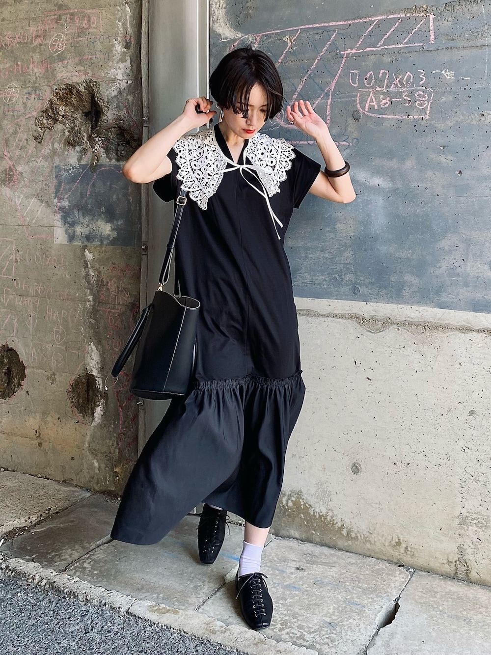 ブラック系のワンピース、ホワイト系のシャツ/ブラウス、ブラック系のショルダーバッグを着用したレディースの夏コーディネートの1枚目の写真
