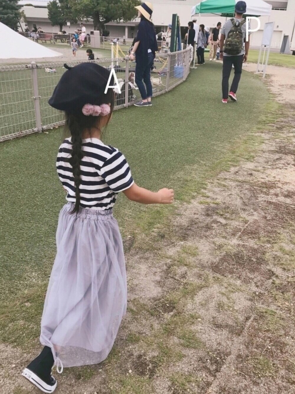 ホワイト系のTシャツ/カットソー、グレー系のスカート、ブラック系のスニーカーを着用したキッズの秋コーディネートの1枚目の写真