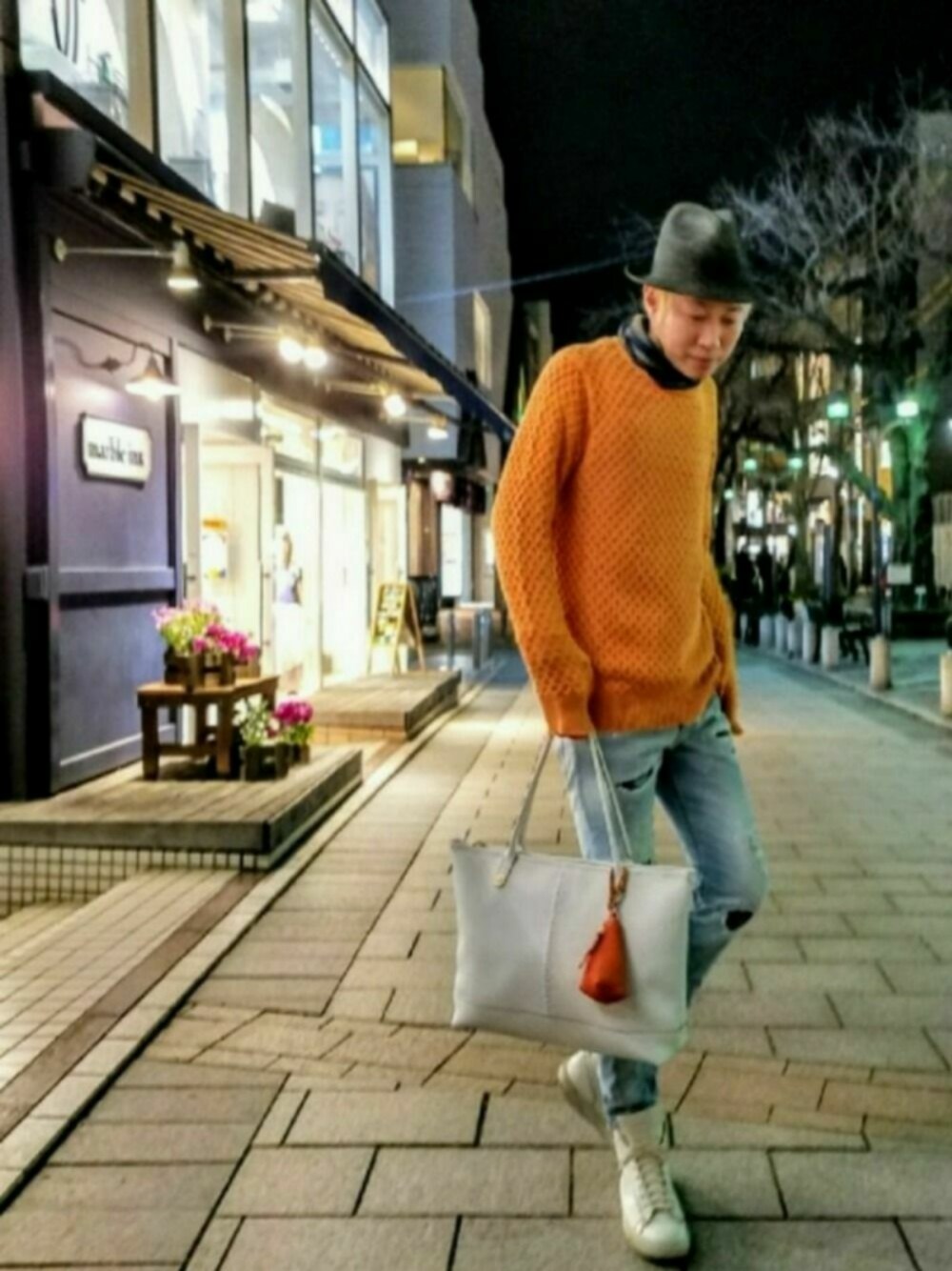 ブルー系のデニムパンツ、ホワイト系のトートバッグ、ホワイト系のシューズを着用したメンズの春コーディネートの1枚目の写真