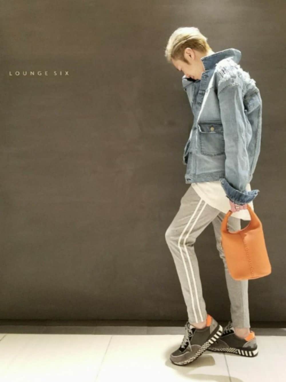 オレンジ系のバッグ、グレー系のその他パンツ、ブラック系のスニーカーを着用したメンズの秋コーディネートの1枚目の写真