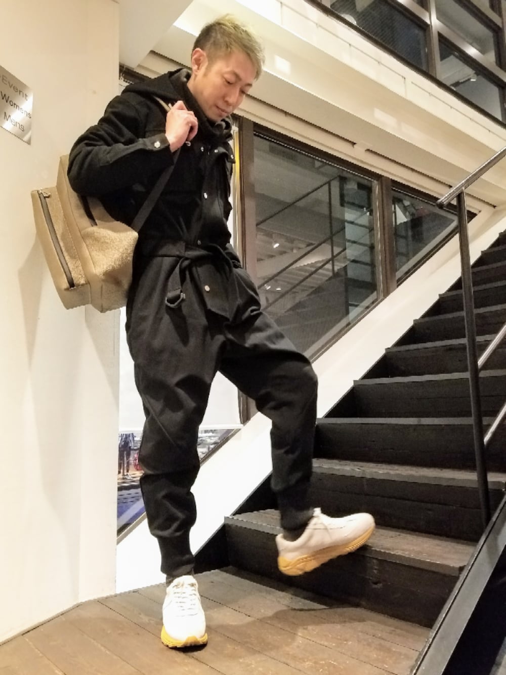 ホワイト系のスニーカー、グレー系のバッグを着用したメンズの冬コーディネートの1枚目の写真