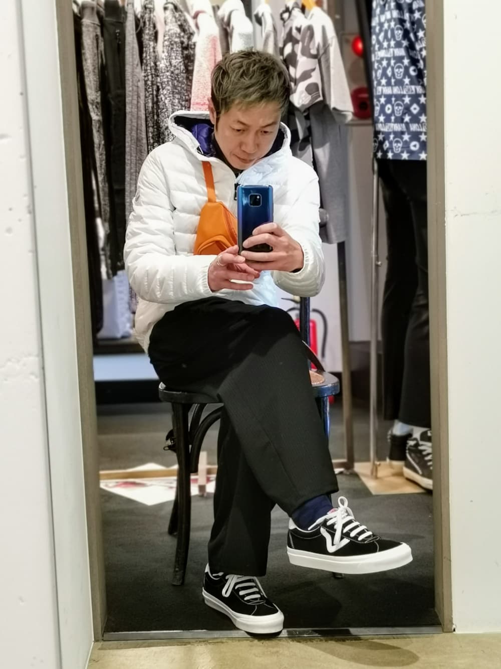 ブラック系のスニーカー、ホワイト系のボディバッグ/ウエストポーチを着用したメンズの冬コーディネートの1枚目の写真