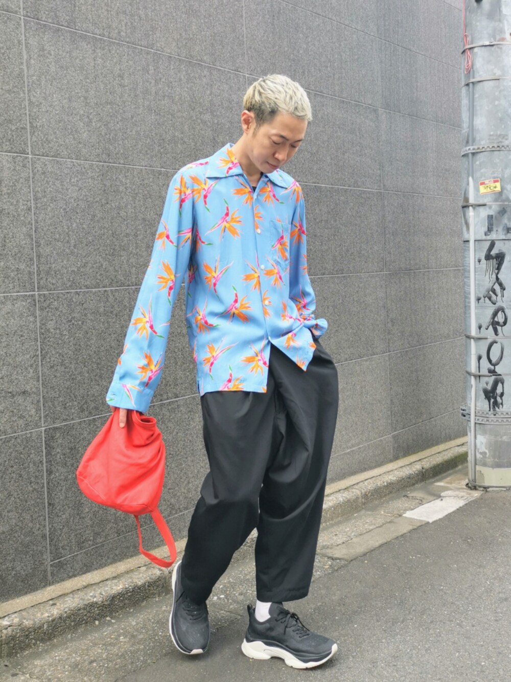 ブラック系のスニーカー、ブルー系のシャツ/ブラウス、レッド系のクラッチバッグを着用したメンズの夏コーディネートの1枚目の写真