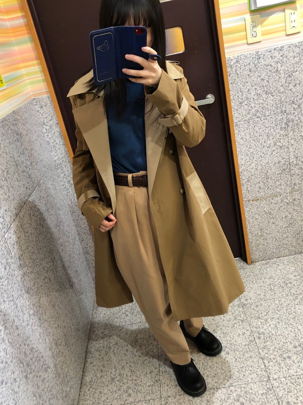 ブラウン系のトレンチコート、ブルー系のニット/セーター、ベージュ系のチノパンツを着用したレディースの春コーディネートの1枚目の写真