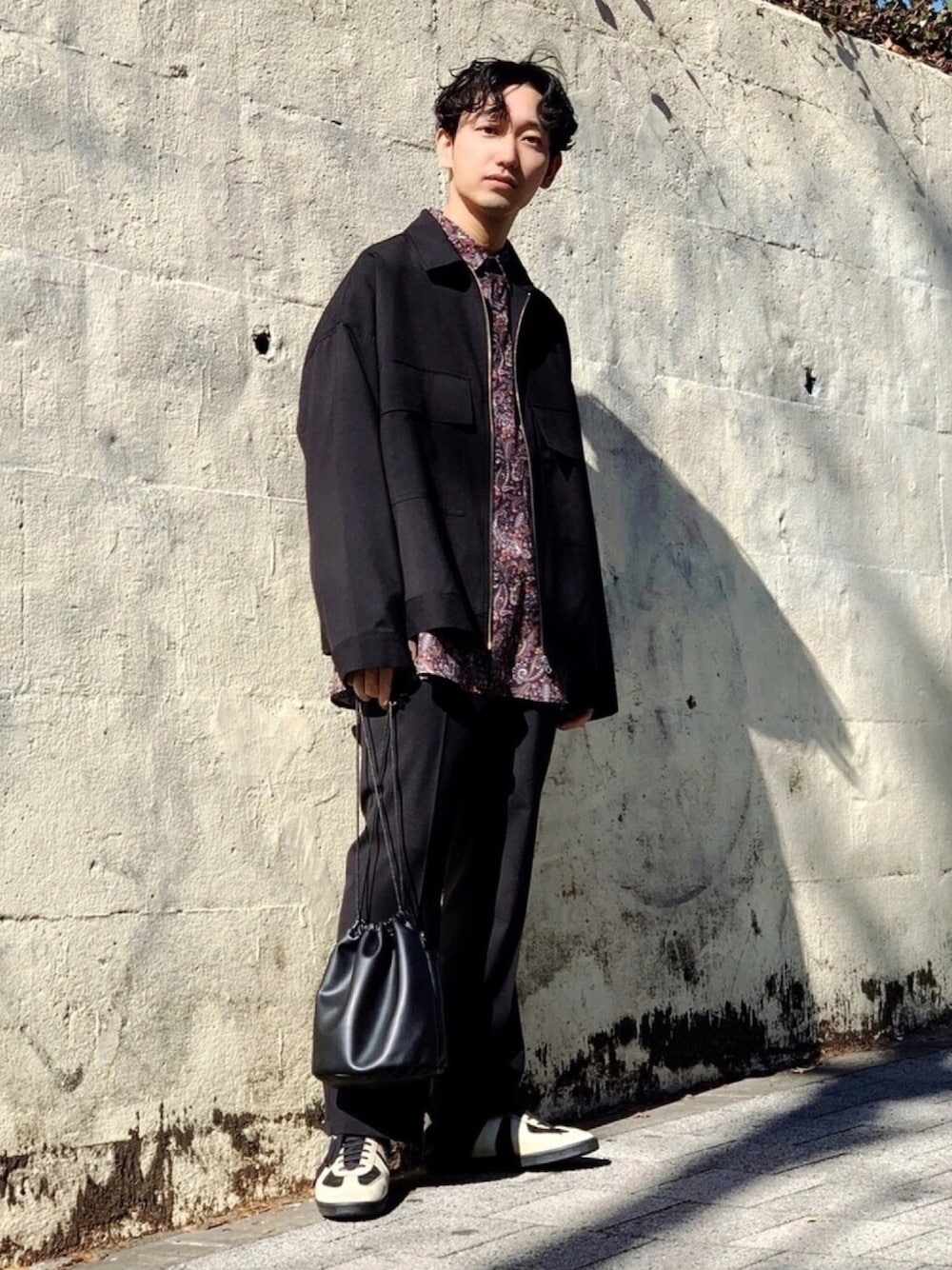 ブラック系のショルダーバッグ、ブラック系のブルゾン、ブラック系のスラックスを着用したメンズの冬コーディネートの1枚目の写真