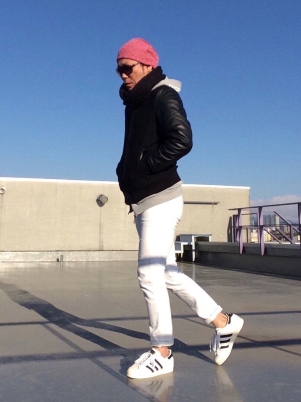 ブラック系のスタジャン、ホワイト系のデニムパンツ、ブラック系のスニーカーを着用したメンズの冬コーディネートの1枚目の写真