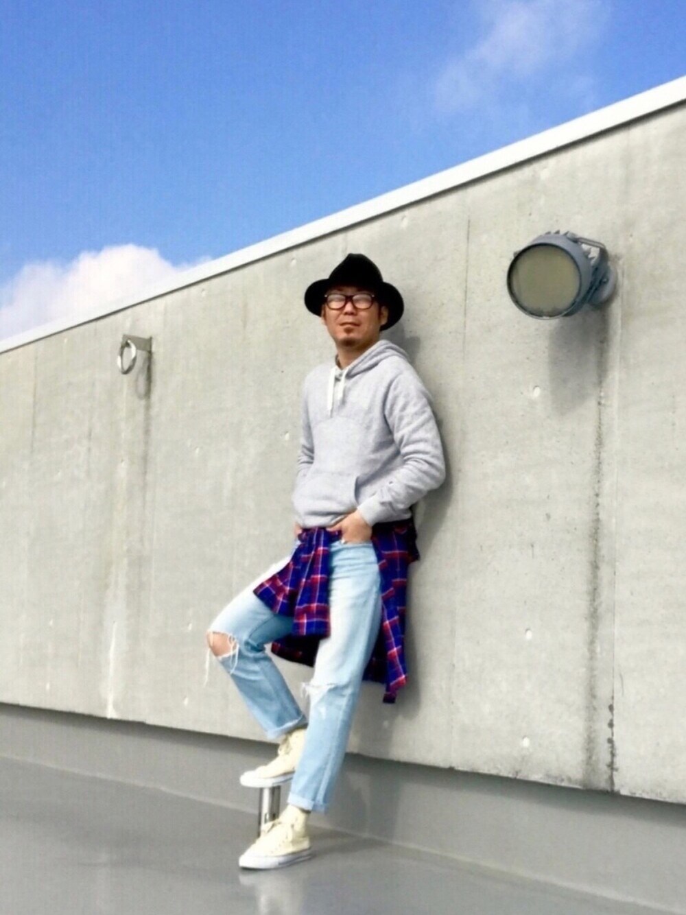 ホワイト系のスニーカー、ブルー系のデニムパンツ、グレー系のパーカーを着用したメンズの春コーディネートの1枚目の写真