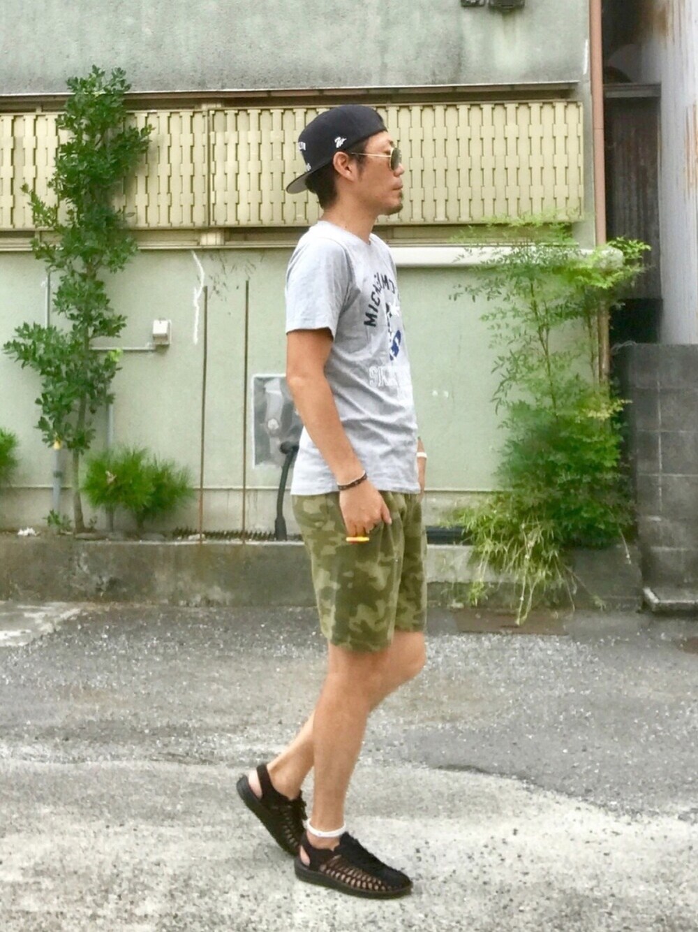 ブラック系のサンダル、グレー系のTシャツ/カットソー、グリーン系のパンツを着用したメンズの夏コーディネートの1枚目の写真