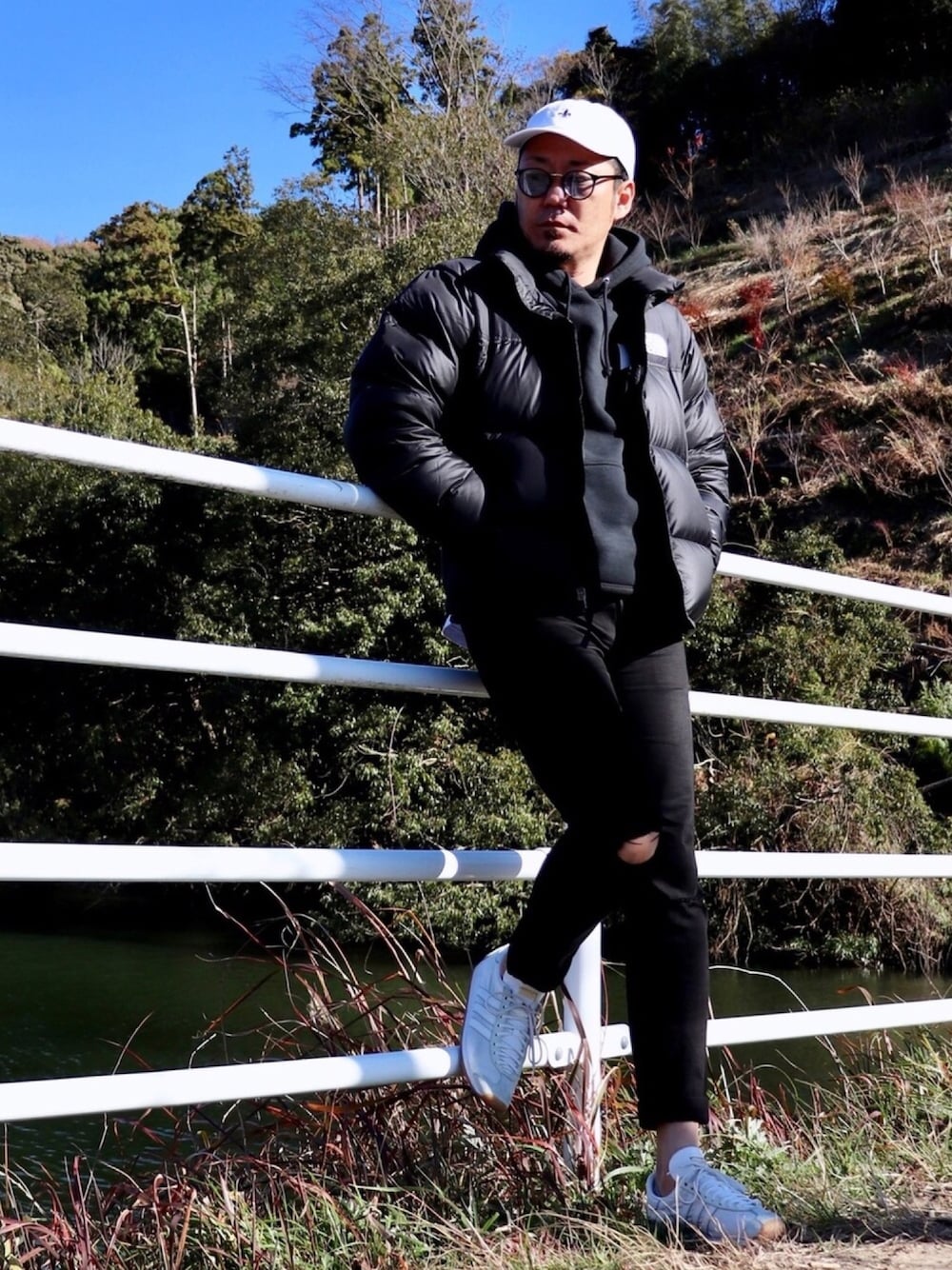 ブラック系のダウンジャケット/コート、ブラック系のパーカー、ブラック系のデニムパンツを着用したメンズの冬コーディネートの1枚目の写真