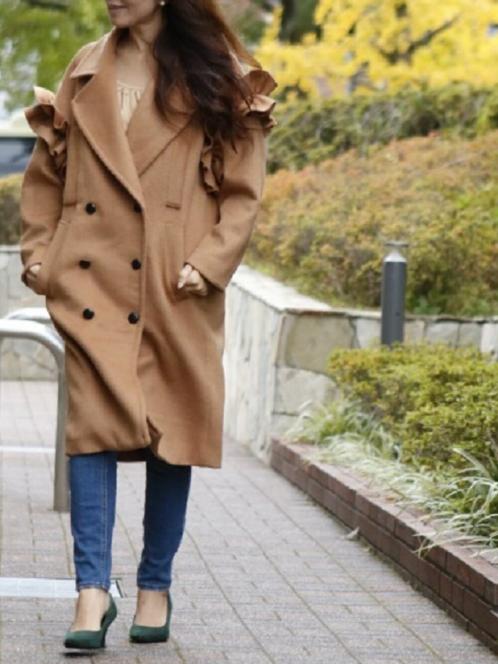 ブラウン系のピーコートを着用したレディースの冬コーディネートの1枚目の写真
