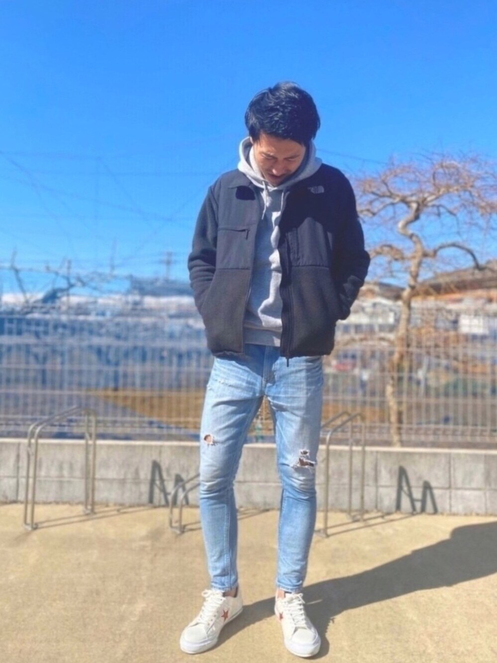 ブラック系のブルゾン、ブルー系のデニムパンツ、ホワイト系のスニーカーを着用したメンズの冬コーディネートの1枚目の写真