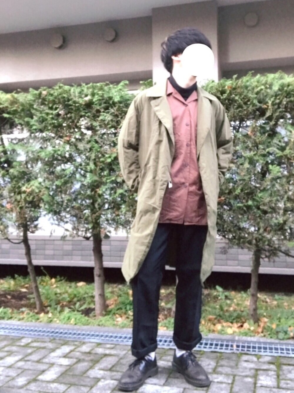 グリーン系のトレンチコート、ブラウン系のシャツ/ブラウス、ブラック系のTシャツ/カットソーを着用したメンズの秋コーディネートの1枚目の写真