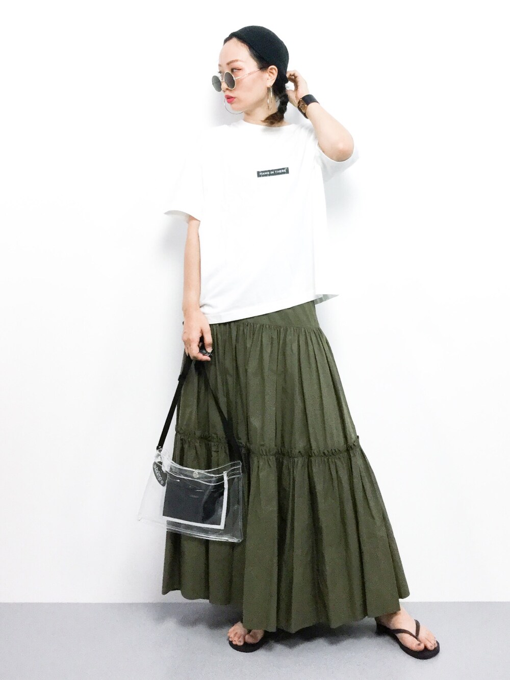 「スカート、カジュアル、Tシャツ、大人カジュアル、カーキ、マキシスカート、ラフ、スカートスタイル、クリアバッグ、ビーチサンダル」｜「JEANASISのピグメントロゴTEE/801584（Tシャツ/カットソー、ホワイト系）」を使った、COLLENTE(yuco)さん（レディース・168cm）の夏コーディネートの1枚目の写真