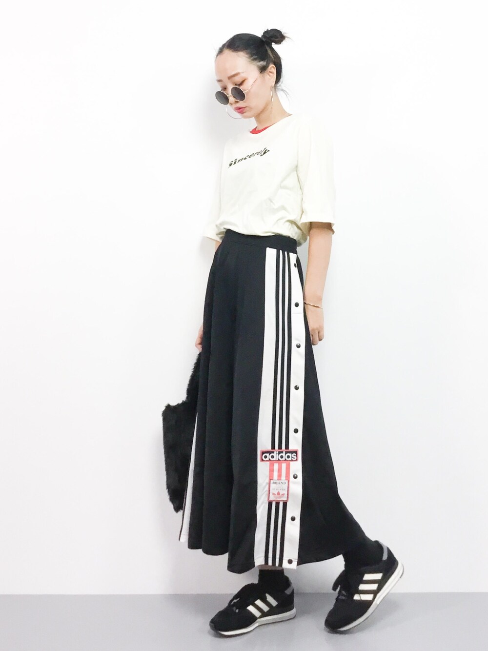 ホワイト系のTシャツ/カットソー、ブラック系のスカートを着用したレディースの秋コーディネートの1枚目の写真